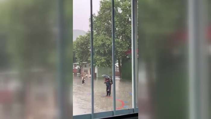 Adana'da bir kişi sağanakta sırtına aldığı torunuyla İstiklal Marşı'nı okudu
