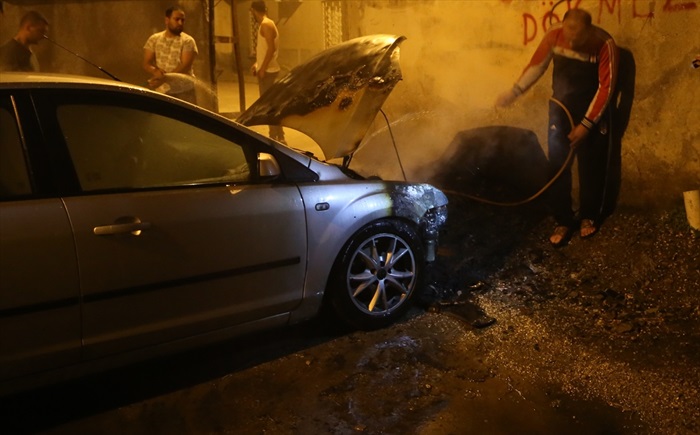 Yanan aracına hortumla müdahale etti