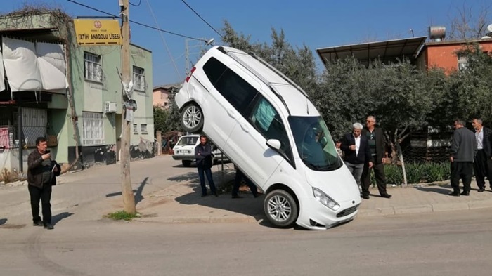 Adana'da ambulansla çarpışan araç, telefon direği halatına asılı kaldı