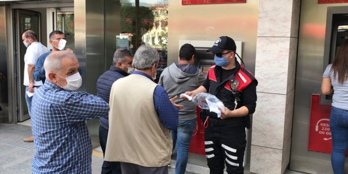 Adana'da polis, banka önlerinde sıra bekleyenlere maske dağıttı