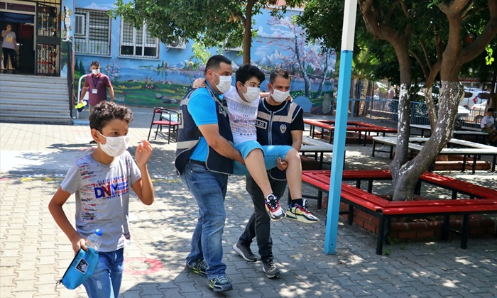 Ayağı kırık öğrenci polislerin kucağında sınava gireceği sınıfa götürüldü